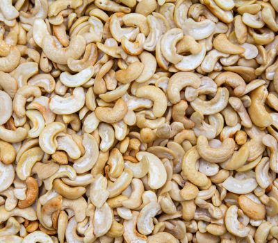 A detailed close-up of roasted cashew nuts creating a textured, appetizing backdrop.