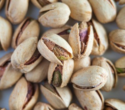 Macro photograph highlighting salted pistachios in their shells, showcasing detail and texture.